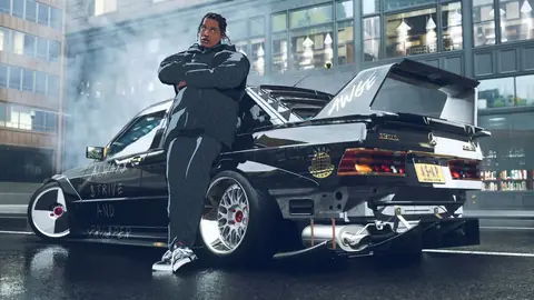 Screenshot von Need for Speed Unbound zeigt einen Charakter, der sich an einen individuell gestalteten Mercedes mit großem Spoiler lehnt