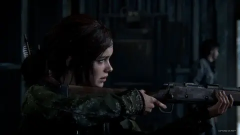 Screenshot von The Last of Us Part I, der Ellie mit einem Gewehr zeigt.